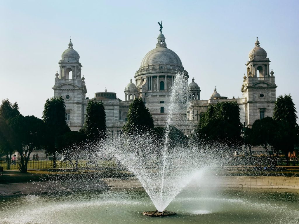 Victoria Memorial in Kolkata with fountain and clear blue sky, capturing architectural elegance.